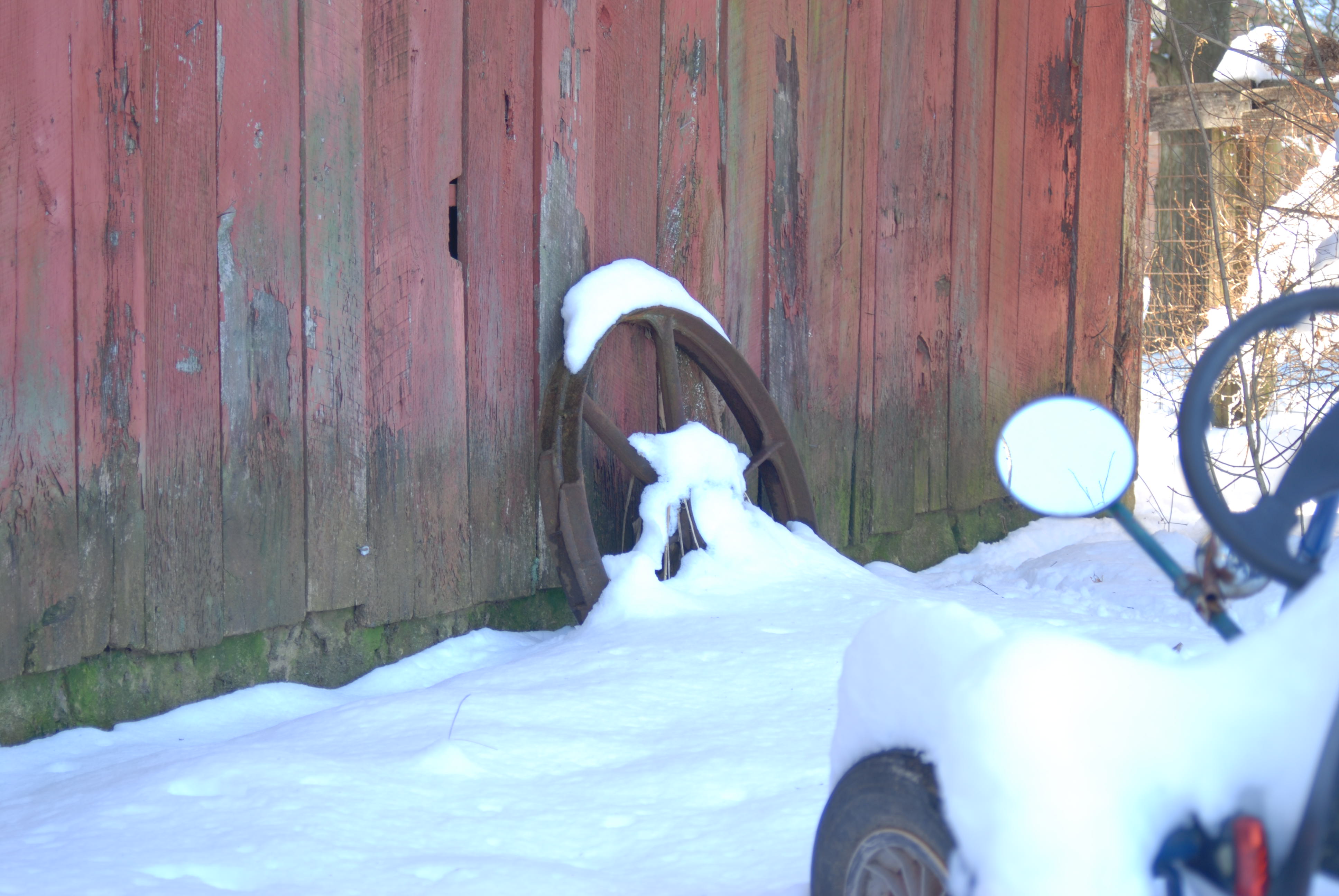 old wagon wheel covered in snow.