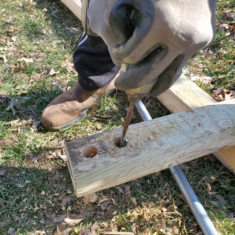 Two holes drilled at the top of each post for the galvanized tubing to pass through
