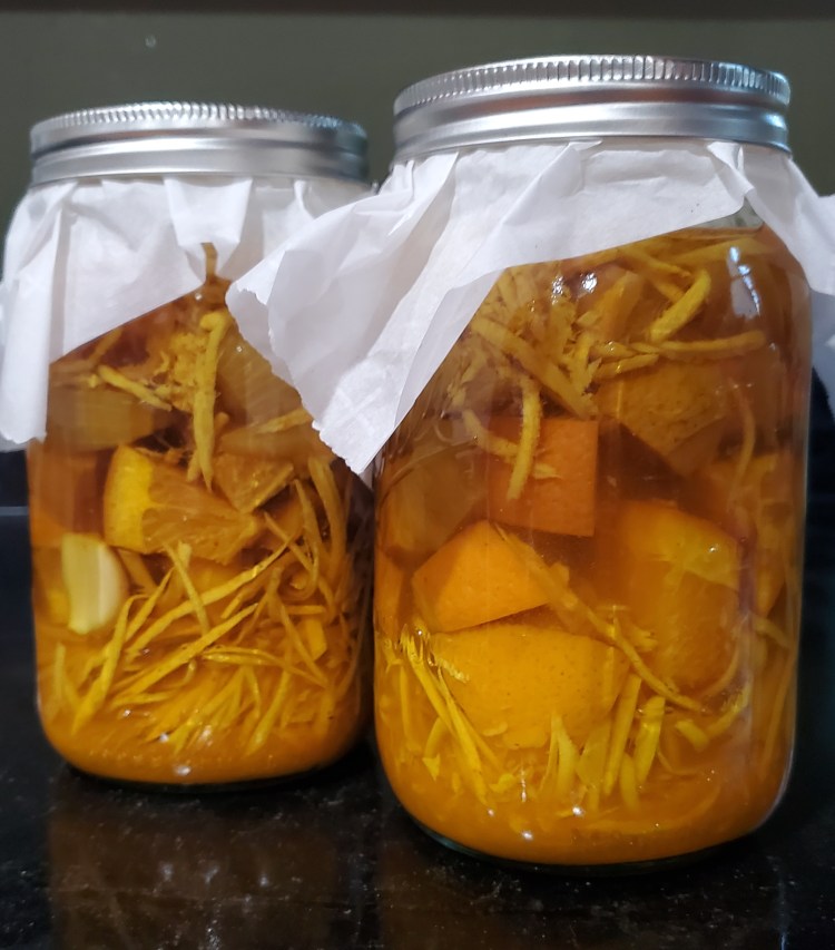 two quart mason jars brewing with fire cider ingredients